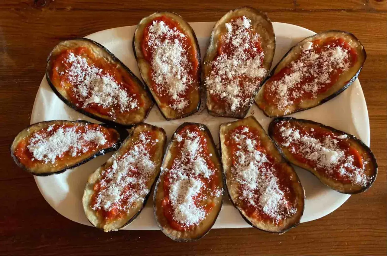 Melanzane a funghetto, cotte al forno e cosparse di parmigiano, pronte per essere gustate.