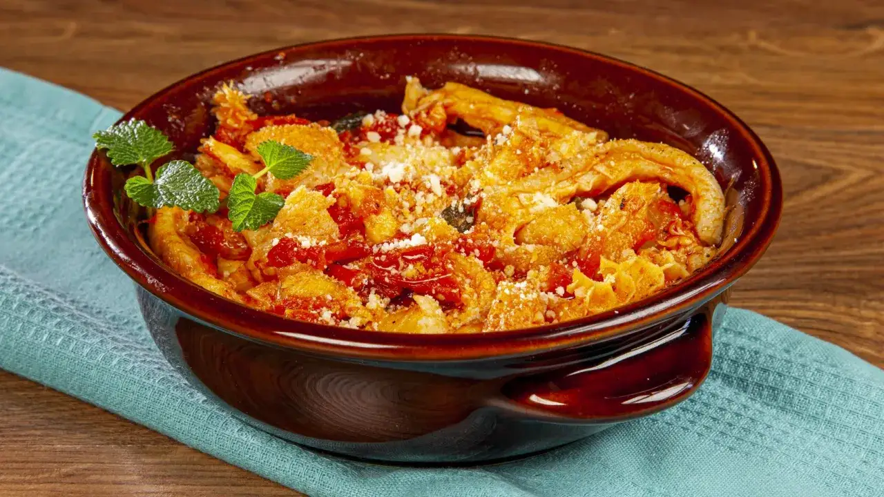 Trippa alla romana in una ciotola di terracotta, guarnita con menta e parmigiano. Un piatto tradizionale romano.