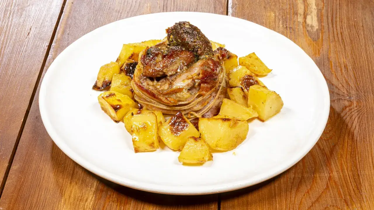 Agnello al forno con patate croccanti, un piatto succulento pronto per essere gustato.