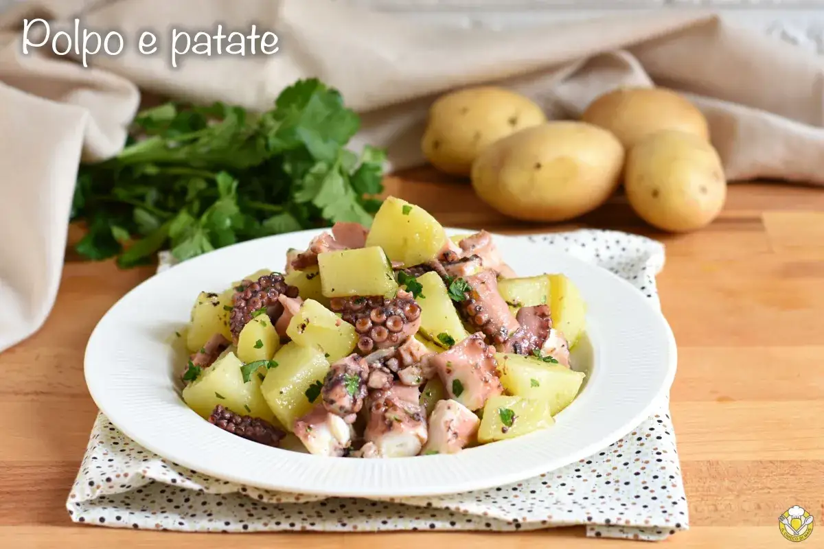 Un saporito polpo con patate, condito con prezzemolo fresco, su un piatto bianco. Sullo sfondo, patate crude e un mazzo di prezzemolo.