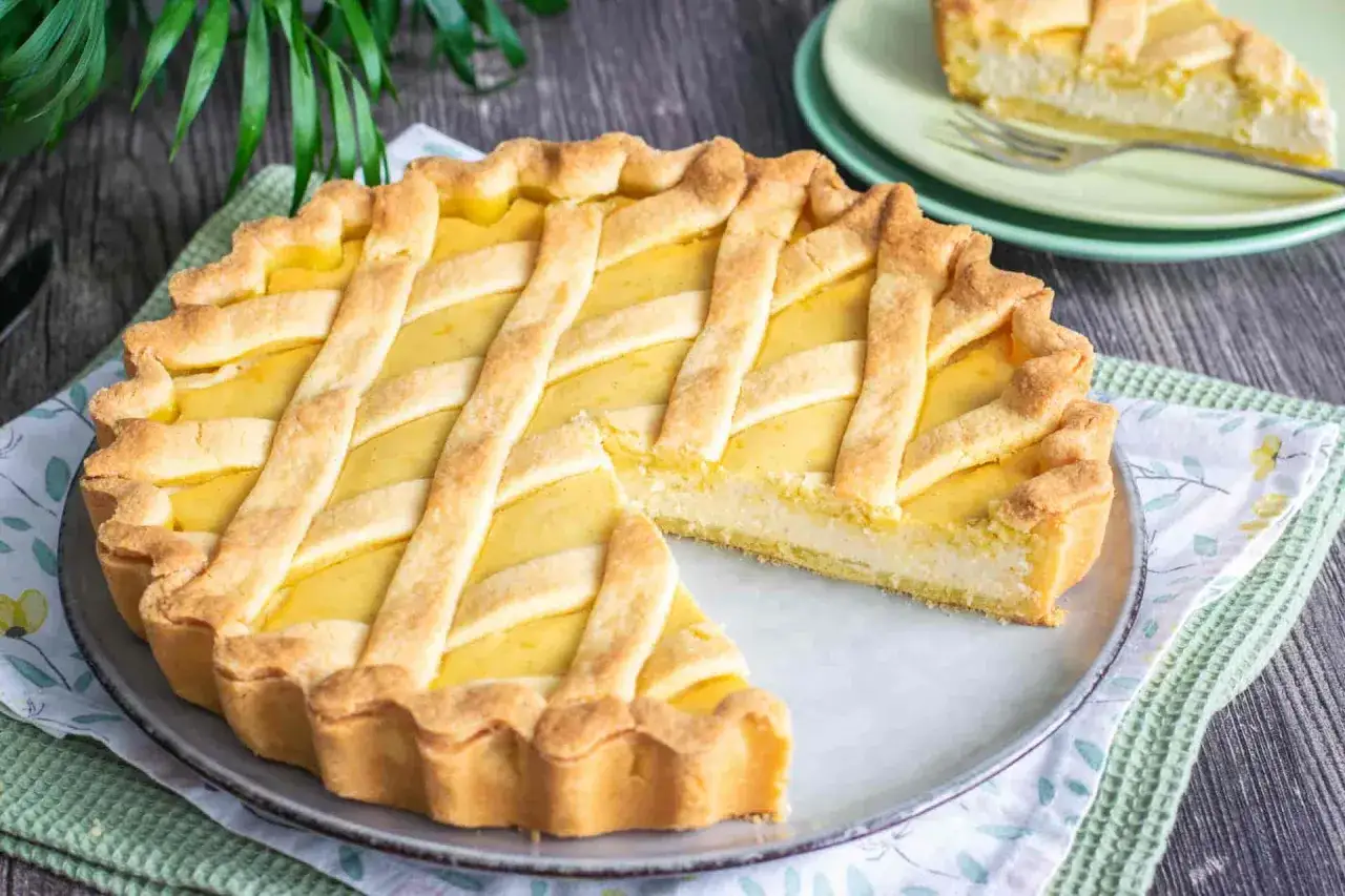 Torta della nonna con crema e ricotta, un dolce invitante con una griglia di pasta frolla dorata.