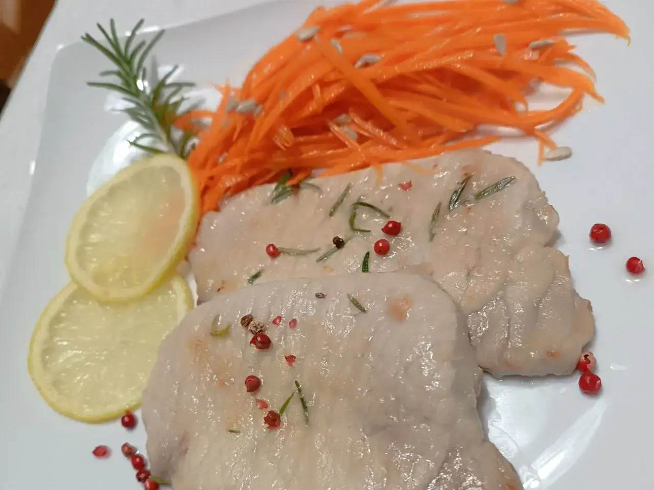 Deliziose scaloppine di maiale con carote julienne, limone, rosmarino e pepe rosa.
