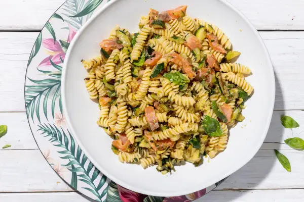 Fusilli con salmone e zucchine, un piatto fresco e colorato, guarnito con basilico.