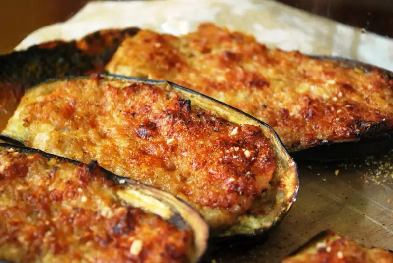 Melanzane ripiene di carne, dorate e gratinate, pronte per essere gustate. Un piatto saporito e invitante.